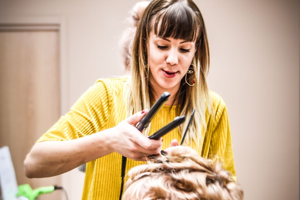 Mia Eliasson skapar volym med hjälp av tång i Annika Magnussons hår.