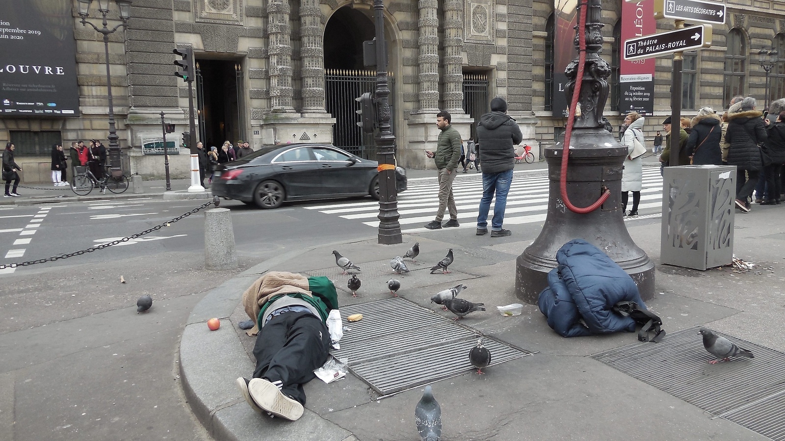 Utanför en av ingångarna till Louvren sover en uteliggare bland duvorna. Foto: Privat