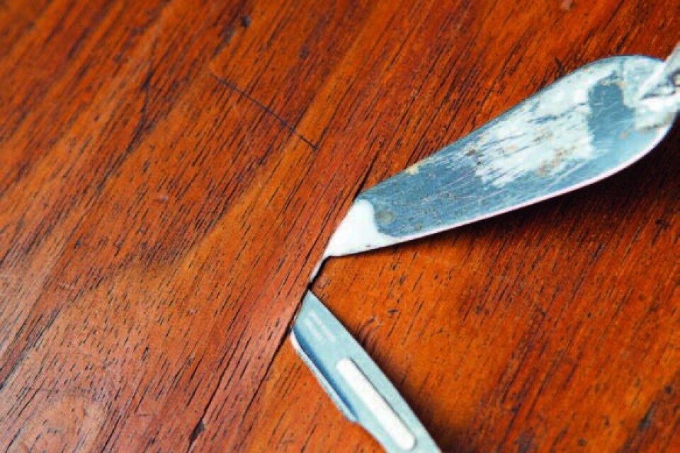 När du har hittat en blåsa i faneren: Snitta försiktigt i träets längdriktning med en skalpell eller tapetkniv.