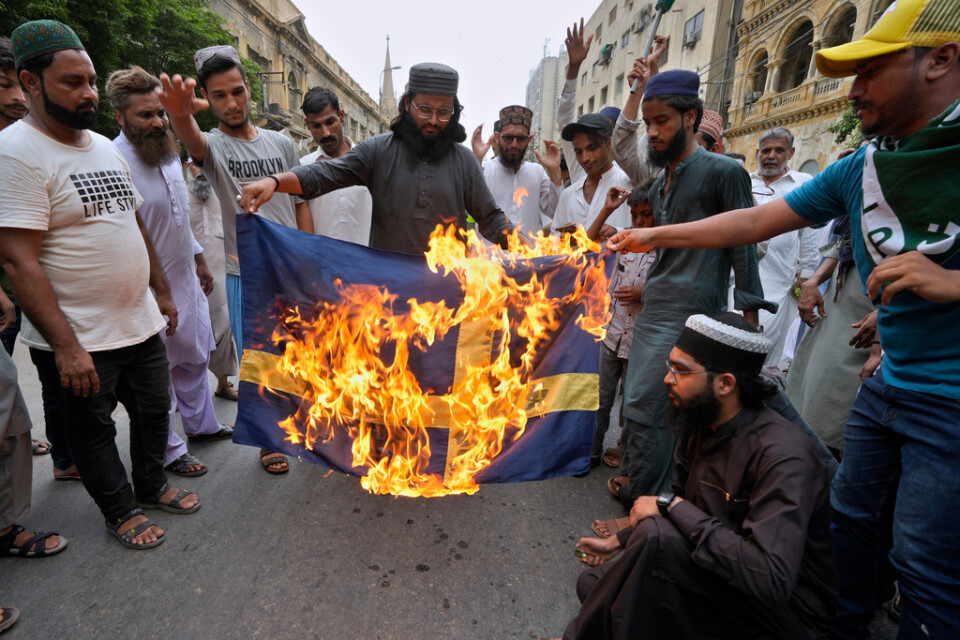 Anhängare till ett radikalt islamistparti i Pakistan bränner ett tygstycke som ska föreställa en svensk flagga i Karachi i fredags förra veckan.