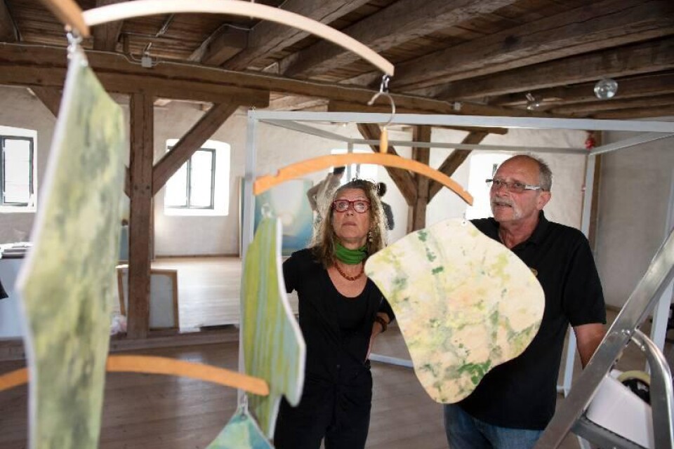 Birgitta Godlund får hjälp av Hans Kristoffersson att bygga sin installation, bland annat bestående av mobilen "Greenwashing."