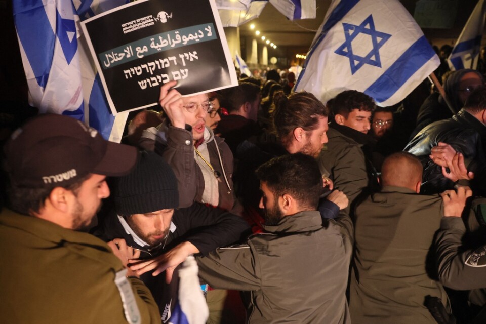 Israelisk polis blockerar vägen för demonstranter i centrala Tel Aviv under protester mot regeringen på lördagen.