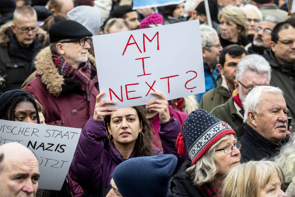 En kvinna håller upp en skylt med texten "Står jag på tur?" under en demonstration i Hanau lördagen efter det misstänkta terrordådet.