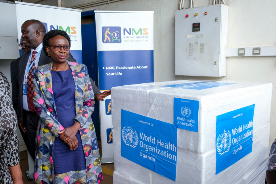 Ugandas hälsominister Jane Ruth Aceng tar emot kartonger med tre olika vaccinkandidater från WHO den 8 december. Arkivbild.