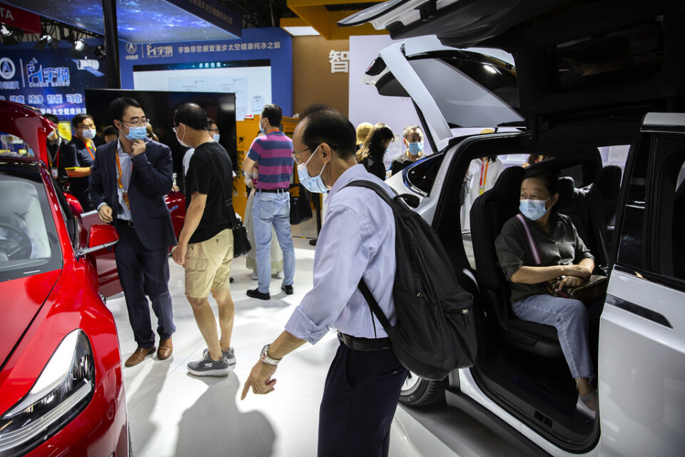 Besökare på en bilmässa i Peking provsitter Teslas elbilar. Arkivbild