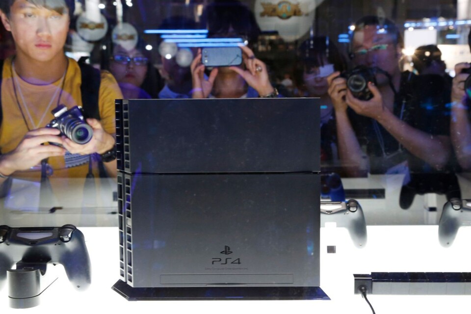 Människor tar bilder på konsolen Playstation 4 vid Tokyo Game Show 2013. Jättarna Sony och Microsoft får i år visa upp sina kommande tv-spelskonsoler på andra sätt.