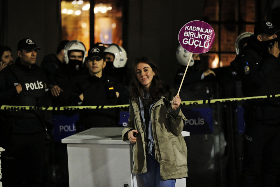 En demonstrant i Istanbul står med ett plakat där det står "Kvinnor är starka tillsammans". Arkivbild.