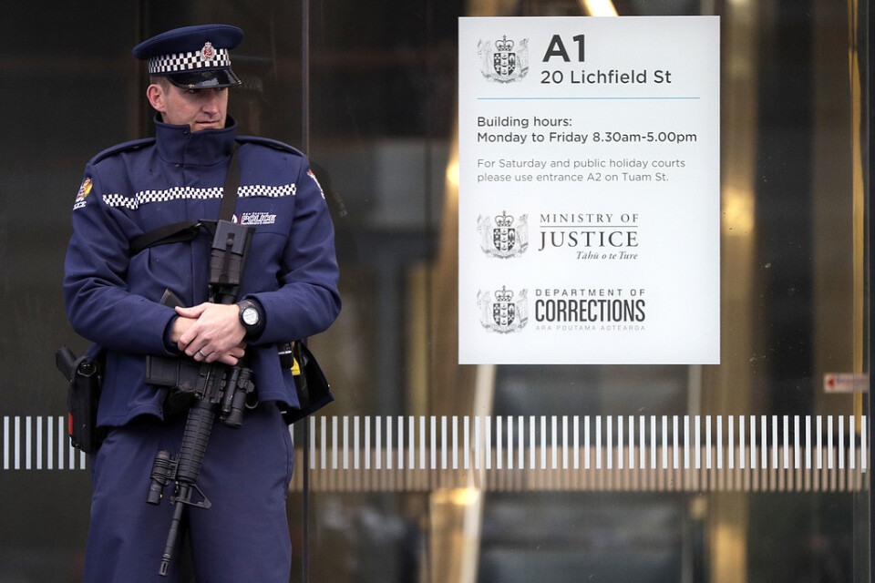En polis vaktar ingången till domstolsbyggnaden i Christchurch, där misstankarna mot den 28-årige Brenton Tarrant presenterades.