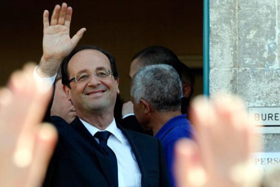 Hollande vinkar efter att ha besökt en vallokal.