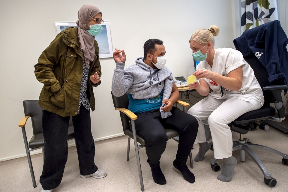 Faisal Ali, från Jemen, har varit rädd men har äntligen bestämt sig. ”Jag går på sfi, då måste jag vara vaccinerad annars måste jag studera på distans”. Buhaa Abdulrahaman tolkar när Louise Palmqvist, sjuksköterska, ska ge sprutan.