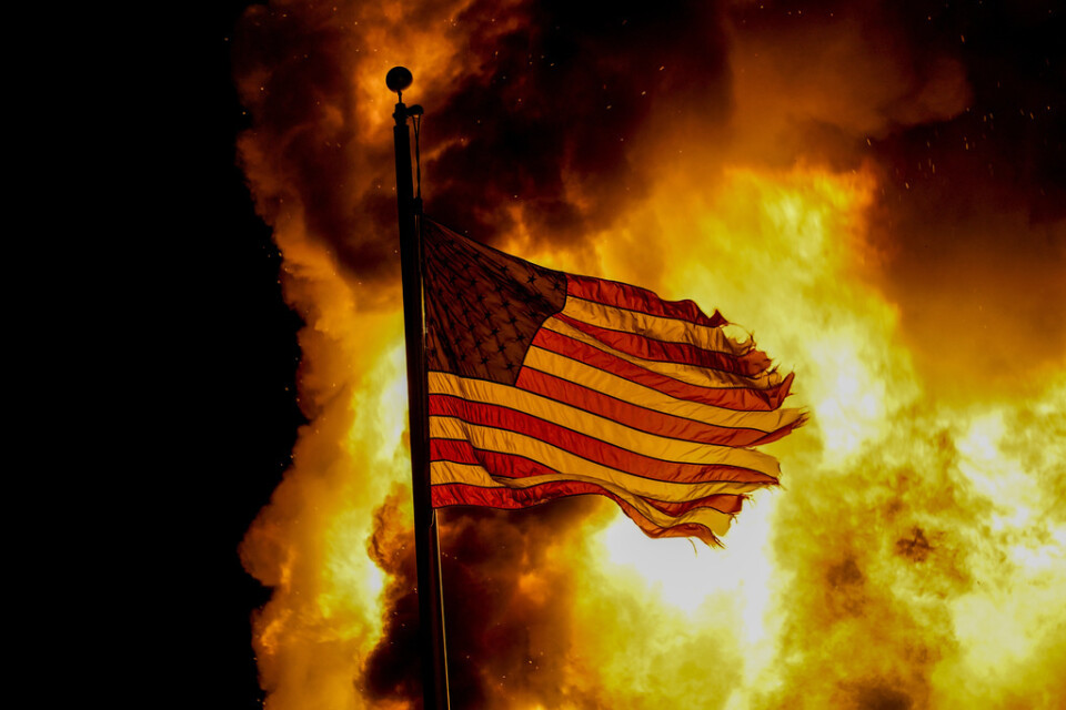 En amerikansk flagga vid en kriminalvårdsanstalt som sattes i brand under protesterna i Kenosha, Wisconsin, i augusti förra året.