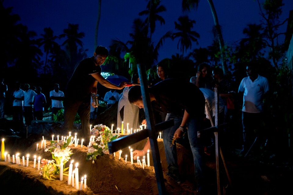 Anhöriga tänder ljus till minne av offren för terrordåden i Sri Lanka.