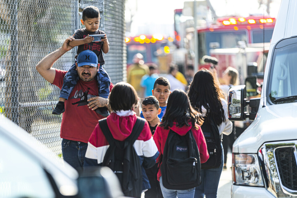 Barn evakueras efter att de och deras skola i stadsdelen Cudahy i Los Angeles fått flygbränsle släppt på sig.
