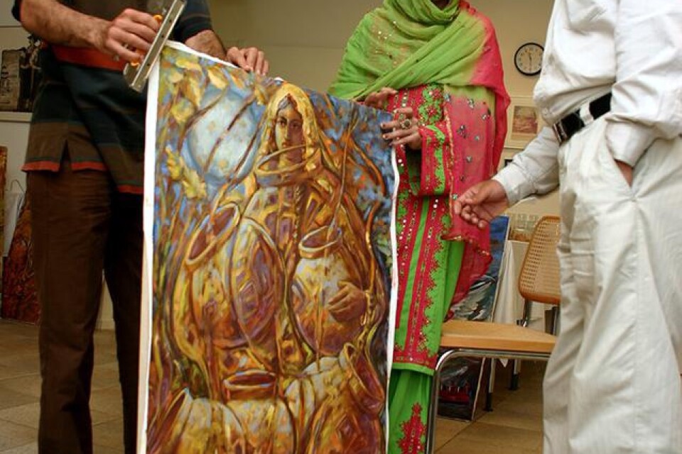 En stor mängd målningar måste monteras på ram innan de kan visas i den stora utställningen. Sima Sardarzahi och Hassan Yadgarzadeh (till höger) får hjälp av Hamzeh Sardarzehi.