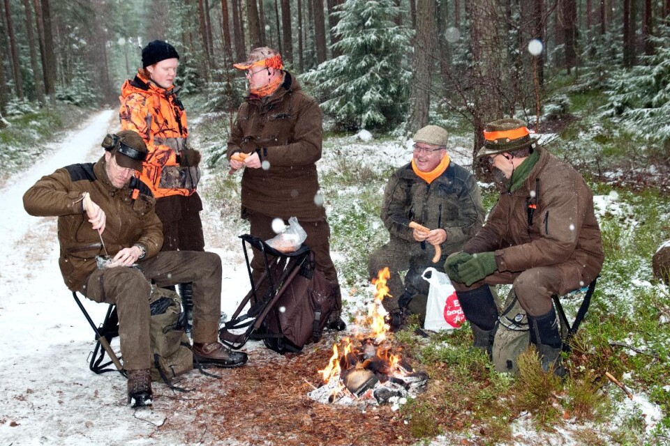 Vid elden grillar jägarna Michael Marchal, till vänster, Kalle och Pelle Berglund, Peter Iburg och Mats Medin korv.