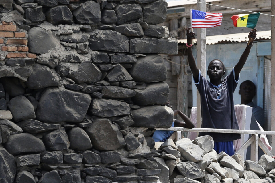 En pojke på Gorée viftade med flaggor i anslutning till att USA:s förre president Barack Obama besökte ön 2013.