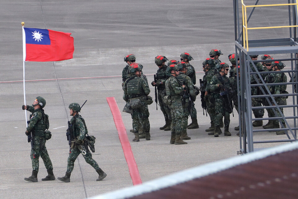 En taiwanesisk soldat håller Taiwans flagga under en stor militärövning i slutet av juli. Den taiwanesiska militären har skakats av flera spionaffärer.
