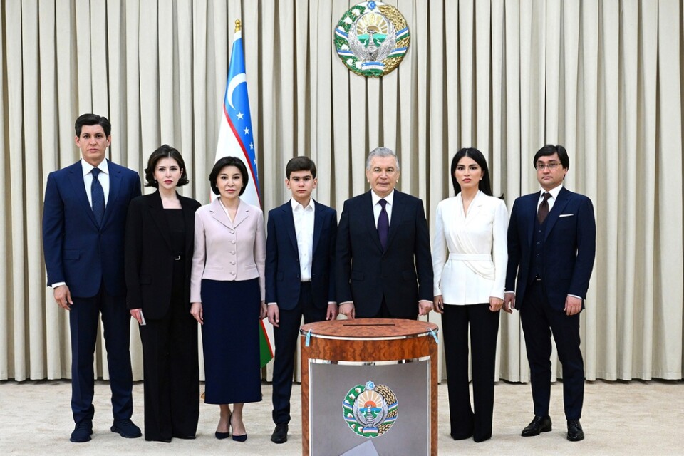 President Sjavkat Mirzijojev, tredje från höger, och hans familjemedlemmar poserar för en bild vid en vallokal i Tasjkent på söndagen.