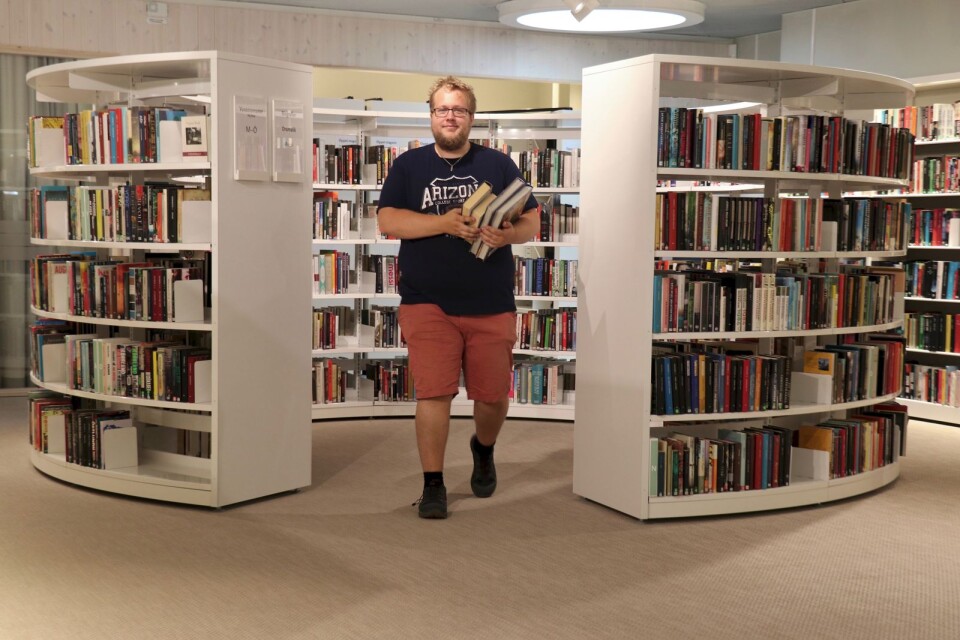 Bibliotekarien Hampus Eriksson är nöjd med sin nya arbetsplats.