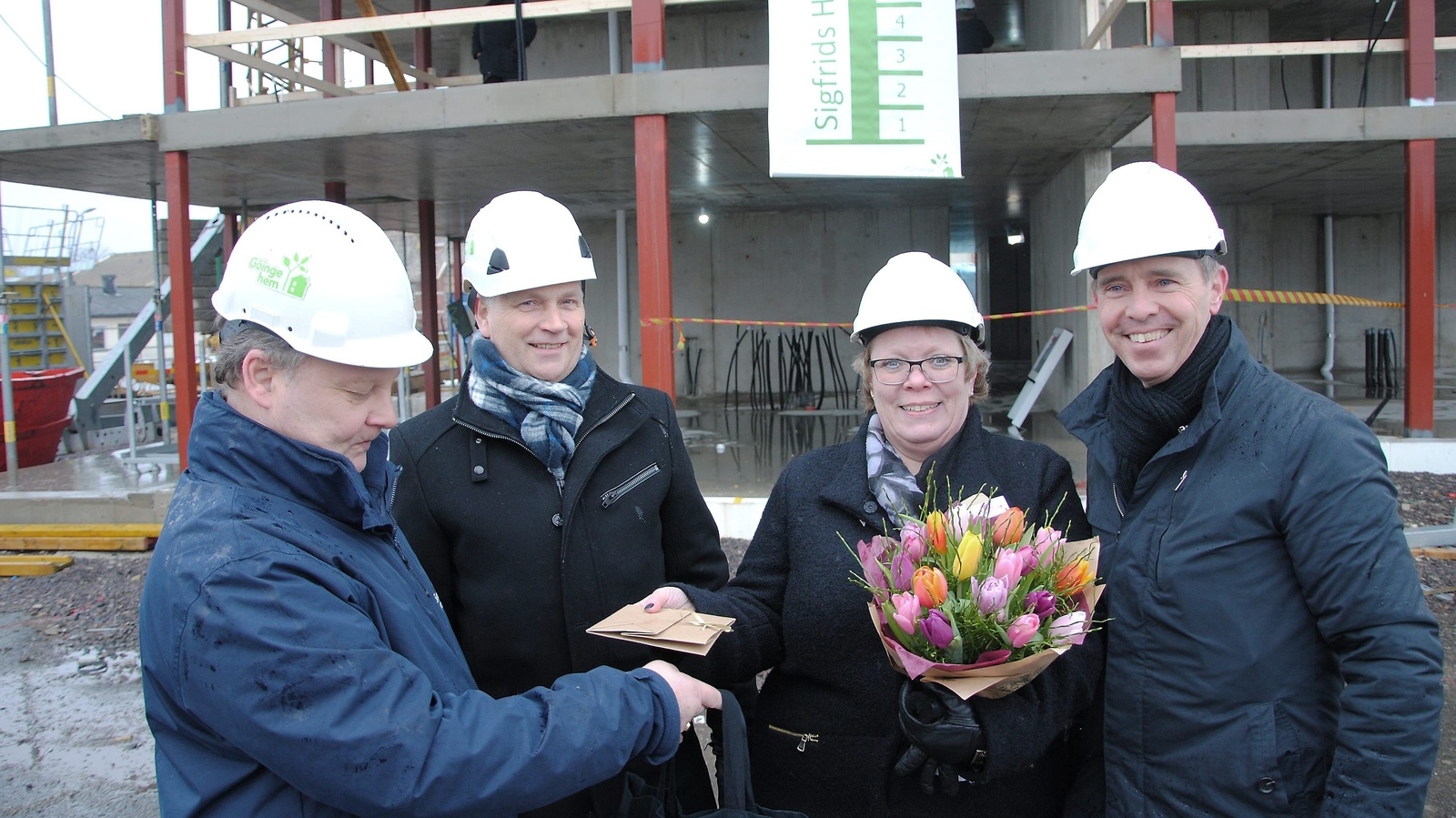 Marie Andersson vann namntävlingen med sitt förslag Sigfrids Höjd. Här grauleras hon av Kent Göstasson, projektledare, Henrik Loveby, vd för Göingehem, och Magnus Nilsson (KD), ordförande i Göingehems styrelse.