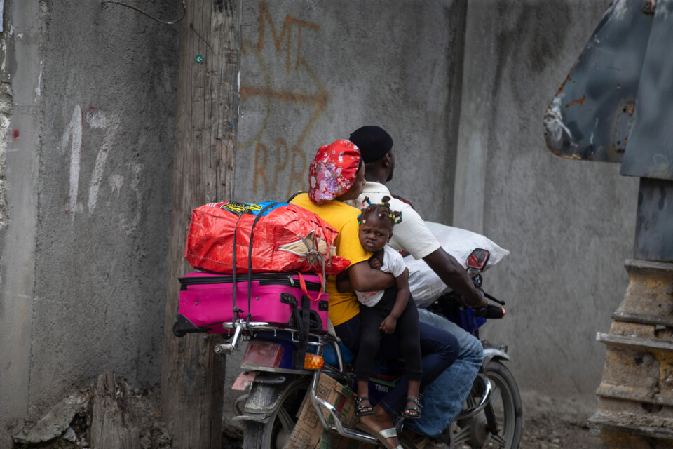 En familj har packat sina tillhörigheter på en motorcykel för att lämna sitt hem, då det sker våldsamma drabbningar mellan väpnade gäng i deras område i Port-au-Prince. Bilden togs den 28 april i år. Arkivbild.