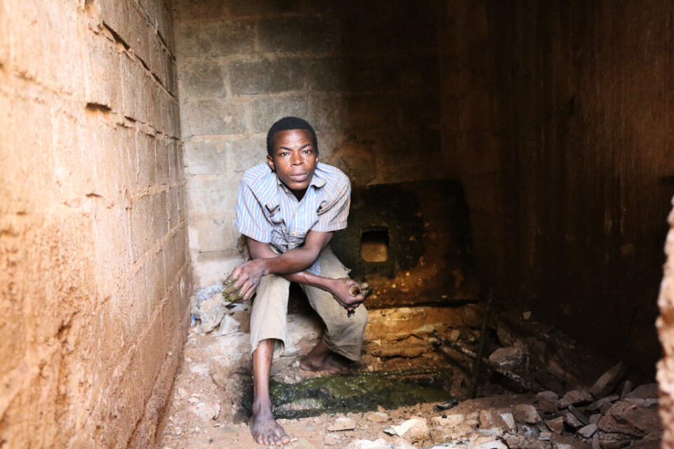 Olivier Batoro, 37 år gammal, står över ett latrinhål som ska tömmas i Burkina Fasos huvudstad Ouagadougou.
