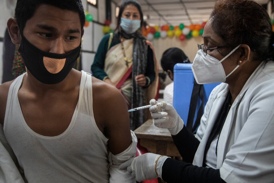 En tonåring vaccineras mot covid-19 i Gauhati i Indien. I landet inleddes på måndagen vaccinering av unga i åldern 15 till 18 år.