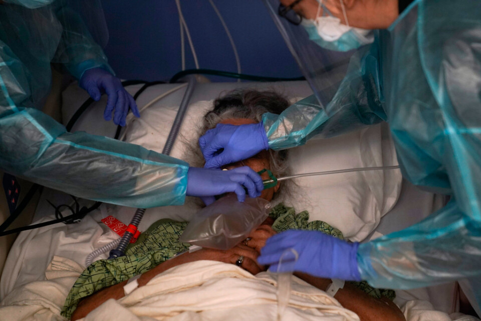 Två sjuksköterskor hjälper en covidpatient på S:t Josephs Hospital i Orange, Kalifornien. Bild från den 7 januari 2021.
