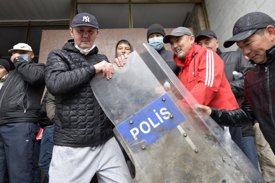 Demonstranter som drabbat samman med polis utanför regeringshögkvarteret i Kirgizistans huvudstad Bisjkek på tisdagen.
