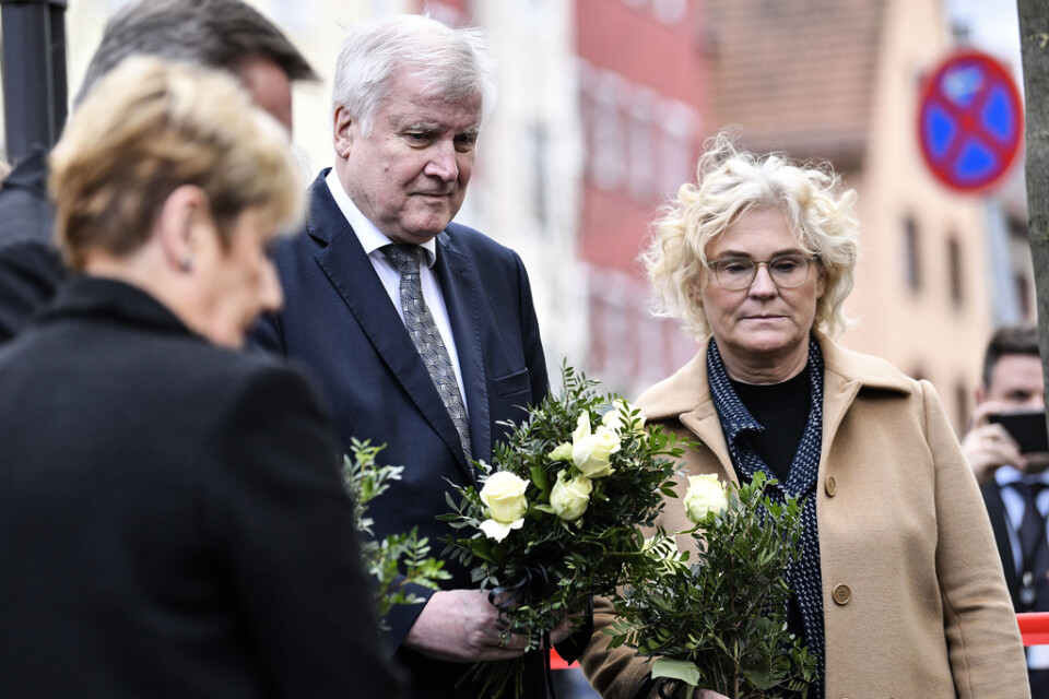 Tysklands inrikesminister Horst Seehofer, i mitten, och justitieminister Christine Lambrecht, till höger, lägger ner blommor utanför ett av de kaféer där flera människor dödades i onsdags.