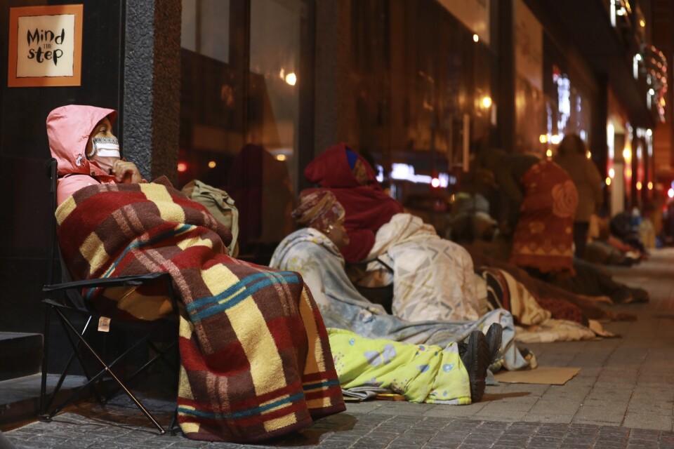 Kvinnor köar före gryningen för att ansöka om ekonomiskt stöd i Kapstaden, Sydafrika, under landets nedstängning i maj.