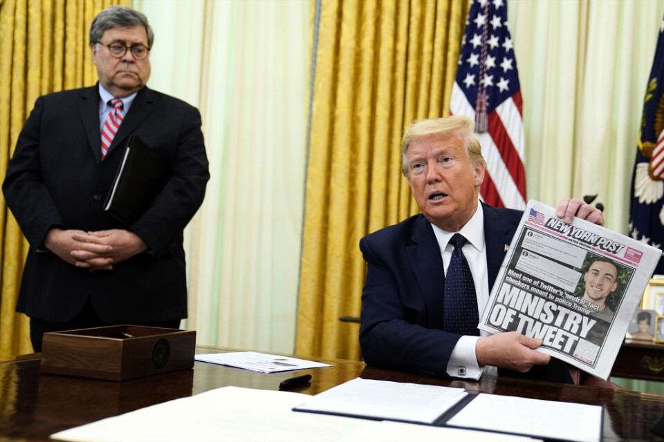 President Donald Trump håller upp ett exemplar av New York Post i samband med signeringen av en presidentorder om sociala medier i Vita huset på torsdagen.