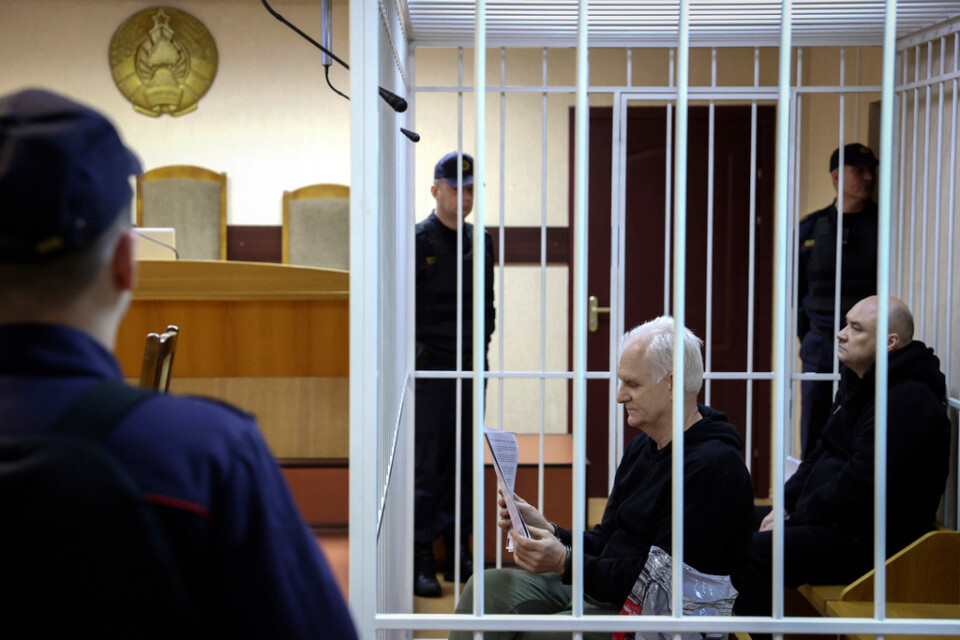Ales Bjaljatski sitter och läser i domstolen i Minsk, den 5 januari. Till höger om honom i bild sitter den medåtalade kollegan Valjantsin Stefanovic. Arkivbild.