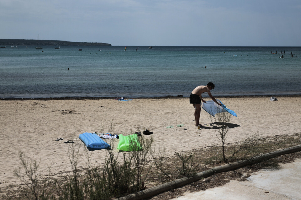 Glest på stranden. En solbadare lägger sig till rätta på en strand på Mallorca. Arkivbild.