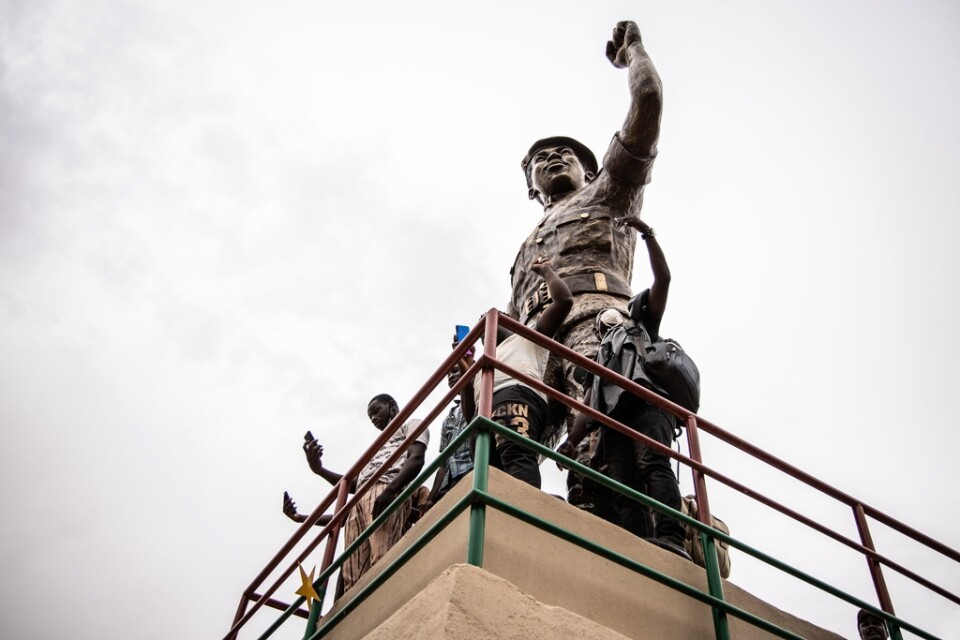 Anhängare poserar vid den omarbetade statyn av Burkina Fasos före detta president Thomas Sankara då den presenterades den 17 maj i huvudstaden Ouagadougou.