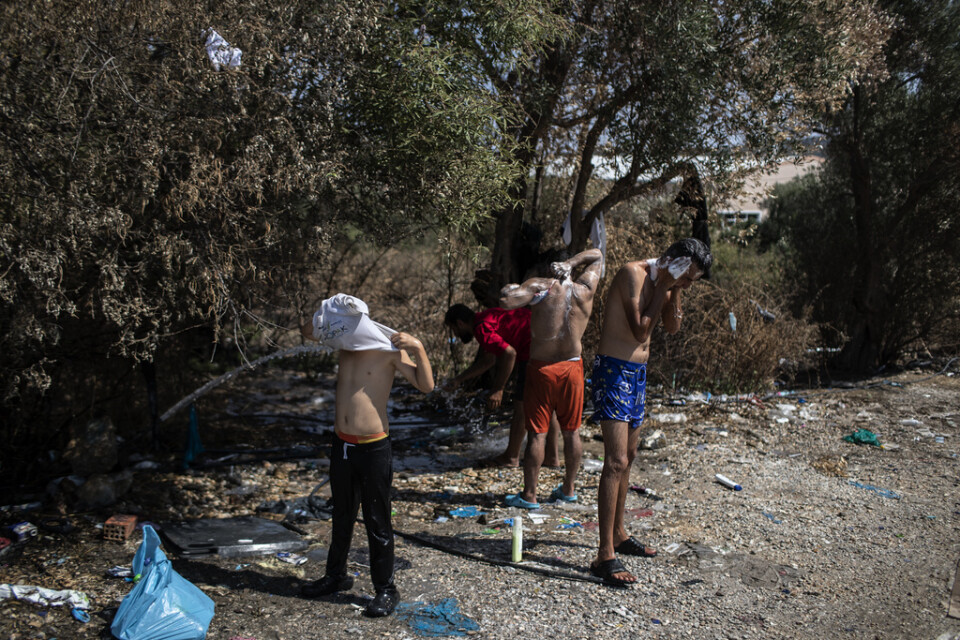 Hemlösa migranter sköter sin hygien utanför det nedbrunna lägret Moria på Lesbos.