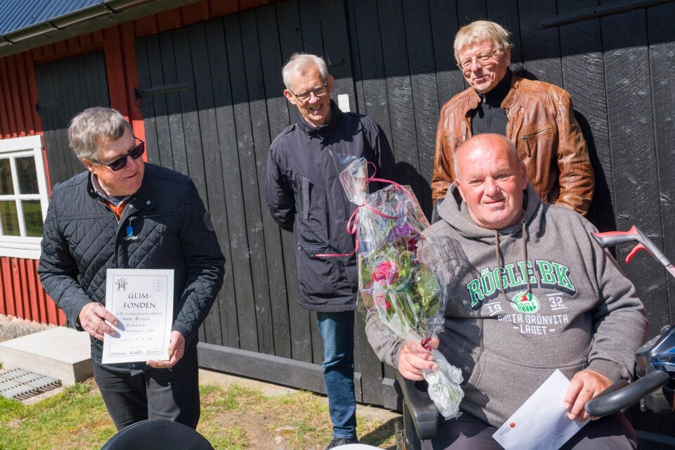 Hembygdsföreningens ordförande Sven Nilsson kollar så att det är "rätt" lag på stipendiatens Matts Perssons tröja. Per-Erik Mattsson och Jörgen Persson överlämnade förutom check även blomster och diplom.