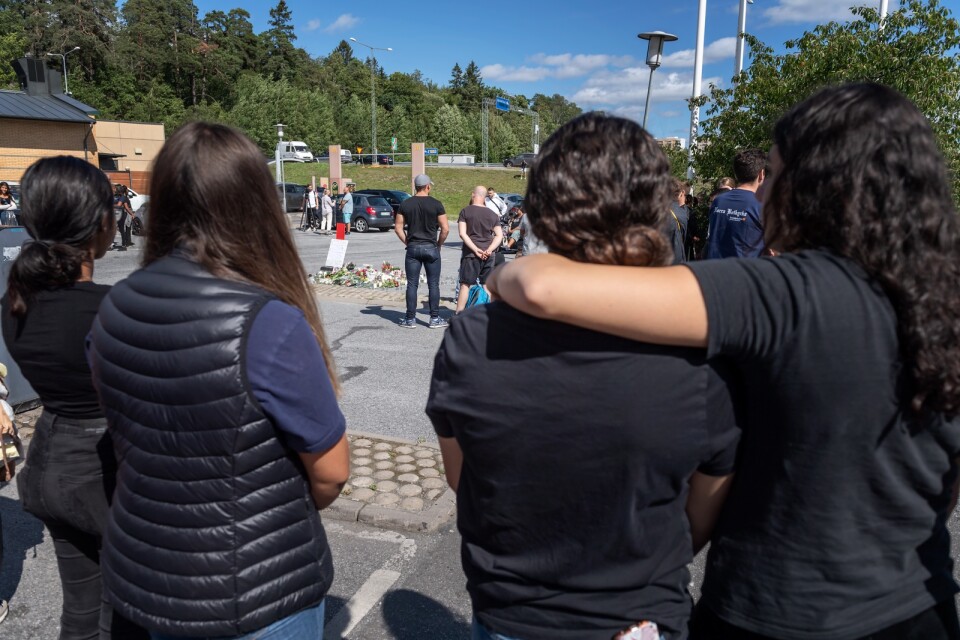 Folk samlas vid blommorna och ljusen på platsen där en tolvårig flicka sköts ihjäl vid en bensinmack i Hallunda i Botkyrka, söder om Stockholm natten mot söndagen.