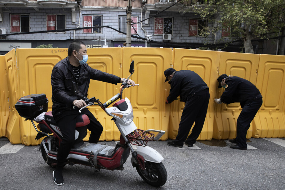Plastbarriärer, som sattes upp för att skilja av bostadsområden från varandra under virusutbrottet, rivs i den centralkinesiska staden Wuhan.