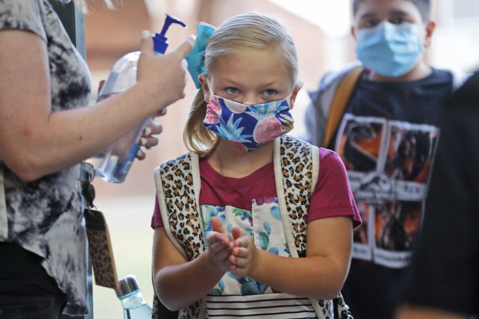 Elever på en grundskola i Godley, Texas, desinfekterar sina händer inför skoldagen. Arkivbild.