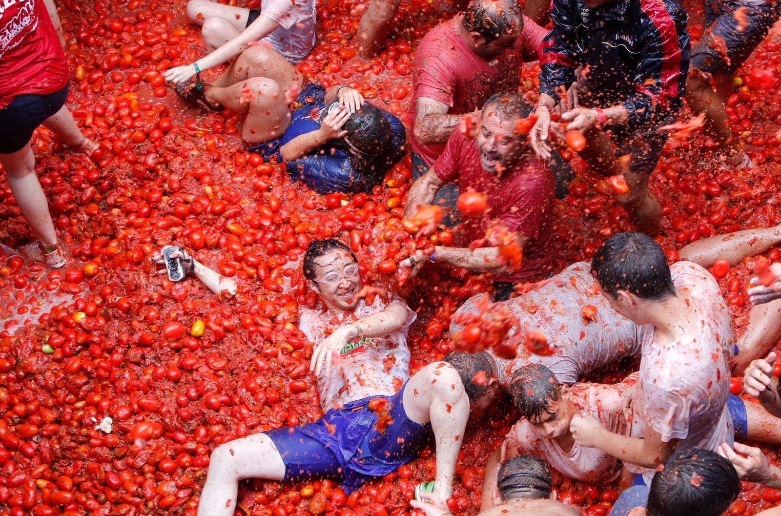 Revelers enjoy as they throw tomatoes at each other, during the annual "Tomatina", tomato fight fiesta, in the village of Bunol, 50 kilometers outside Valencia, Spain, Wednesday, Aug. 30, 2017. At the annual "Tomatina" battle, that has become a major tourist attraction, trucks dumped 160 tons of tomatoes for some 20,000 participants, many from abroad, to throw during the hour-long Wednesday morning festivities. (AP Photo/Alberto Saiz)