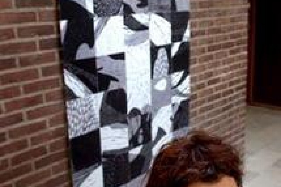 Annette Lindstedt visar sin konst för första gången i Trelleborg. Här syns ett linoleumstryck som förstorats upp på textil bakom konstnären. Goto: Tomas Nyberg