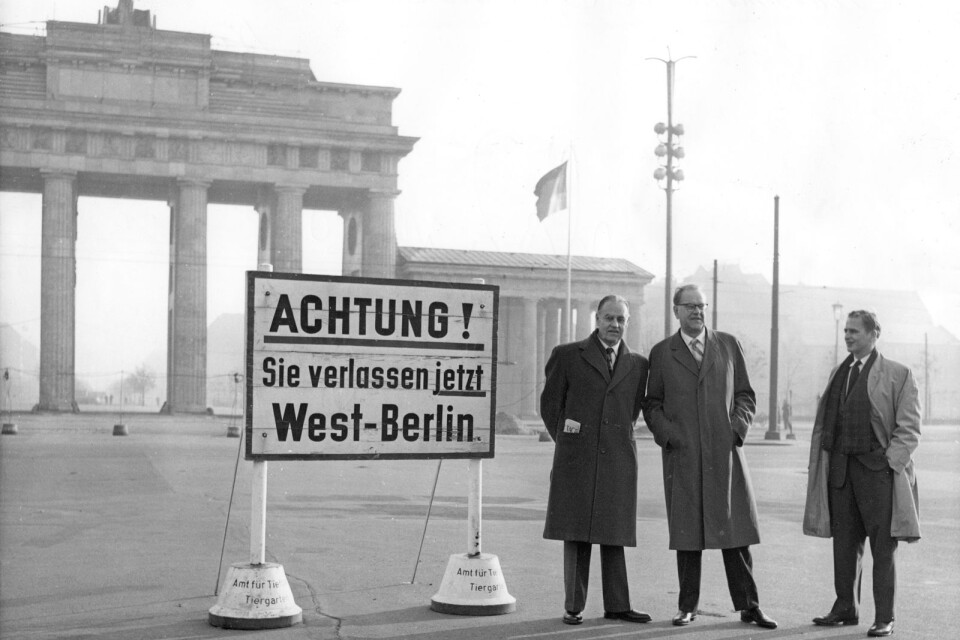 Statsminister Tage Erlander (S) och hans assistent Olof Palme vid gränsen till Öst-Tyskland, DDR, med Brandenburger Tor i bakgrunden i samband med det tyska SPD:s kongress 1958.