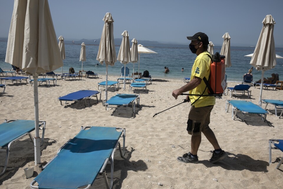 Viruset är fortfarande närvarande. Här desinficeras solstolar på en strand utanför Aten i maj 2021. Arkivbild.