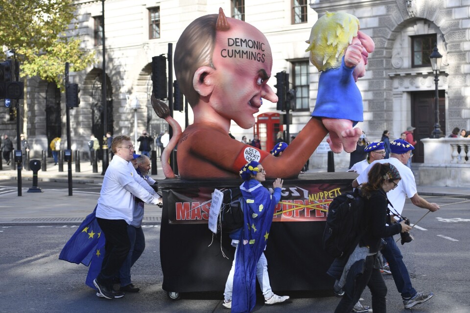 En figur föreställande rådgivaren Dominic Cummings som håller i en kasperdocka som föreställer premiärminister Boris Johnson. Bilden är tagen under en protest anordnad av brexitmotståndare. Arkivbild.