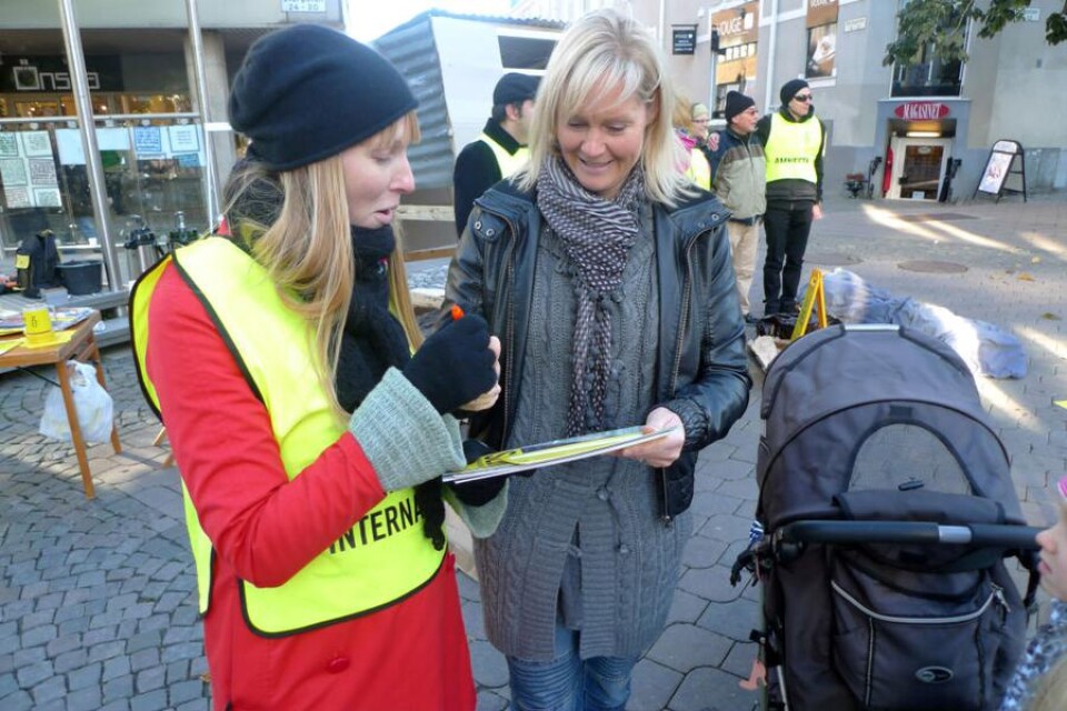 Marie Johansson ger sin röst för Nairobis fattiga när Lotta Gustafsson från Amnesty ber om hennes namnteckning framför ett plåtskjul som byggts upp vid Spakers corner i centrala Växjö.