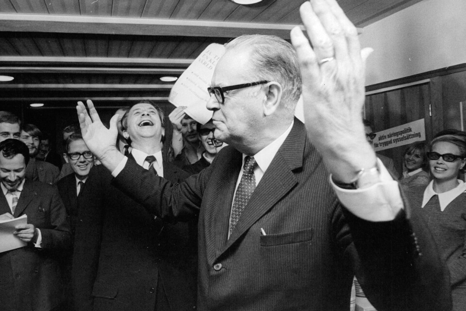 1968 års valsegerherre, statsminister Tage Erlander (S), konstaterar framgången i sitt partihögkvarter under valet. Partisekreterare Sten Andersson skrattar i bakgrunden.
