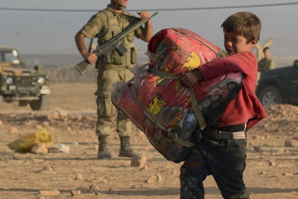 En ung pojke på flykt, vid turkiska gränsen i helgen. Foto: AP/TT