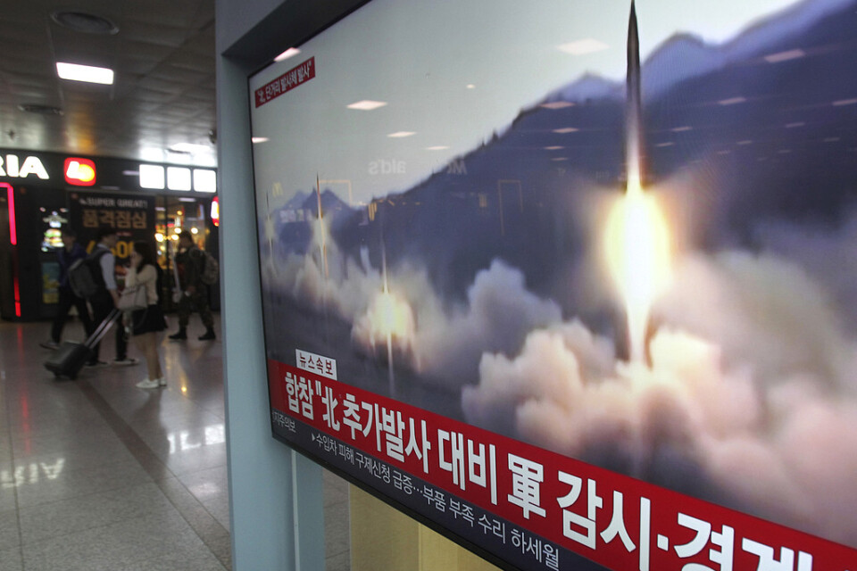 En tv på Seouls centralstation i Sydkorea visar bilder från den nordkoreanska robotövningen.