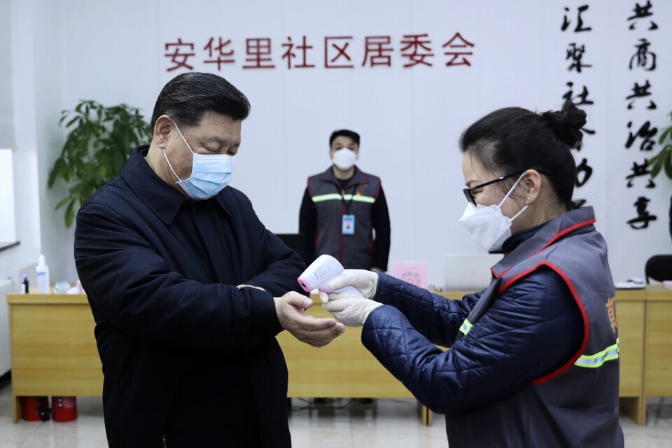 Kinas president Xi Jinping får temperaturen kontrollerad under ett besök på en vårdinrättning i Peking. Bild distribuerad av Kinas statliga nyhetsbyrå Nya Kina.